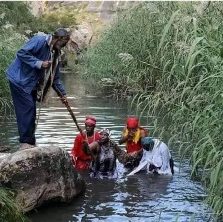 A traditional river cleansing ritual with people standing in flowing water